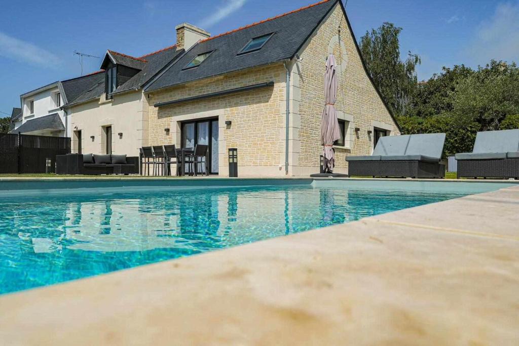 une grande piscine devant une maison dans l'établissement Villa Gozforn - Piscine et plage à pied, à Fouesnant