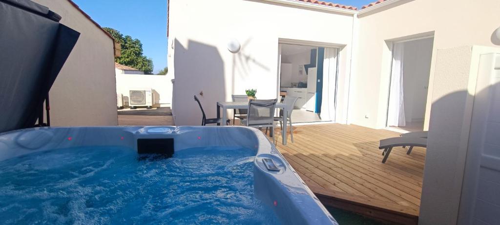 una vasca idromassaggio in un cortile con patio di Heron- Maison avec jacuzzi privatif 4pers a Les Sables-dʼOlonne