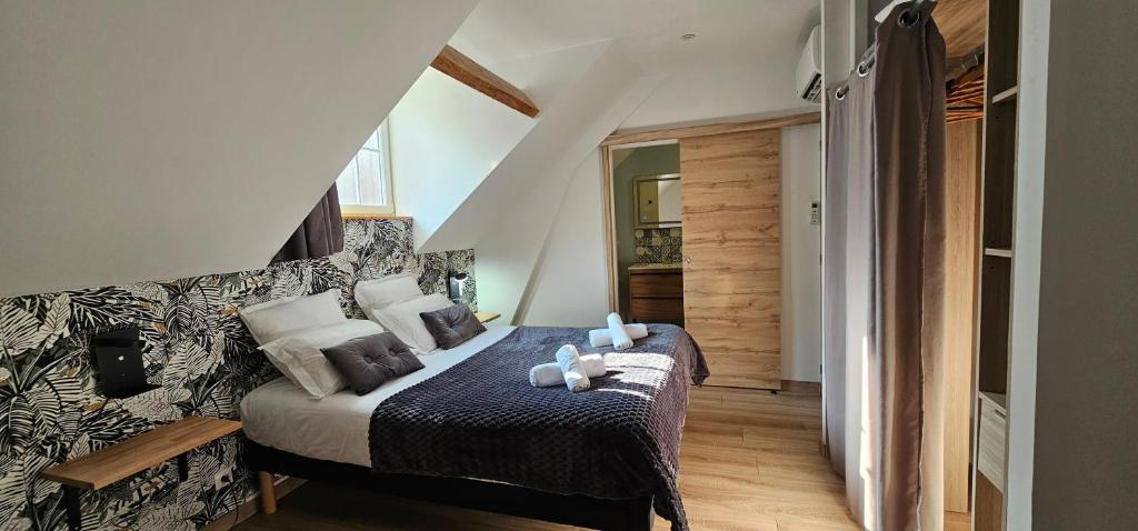 a bedroom with a bed with pillows on it at Le Clos Maldier - Gîte de la Belle vue in Laon