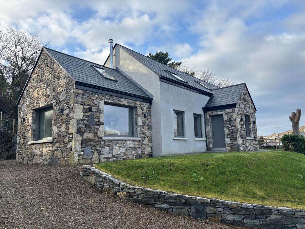 a stone house with a stone wall at Cottage 482 - Clifden in Clifden