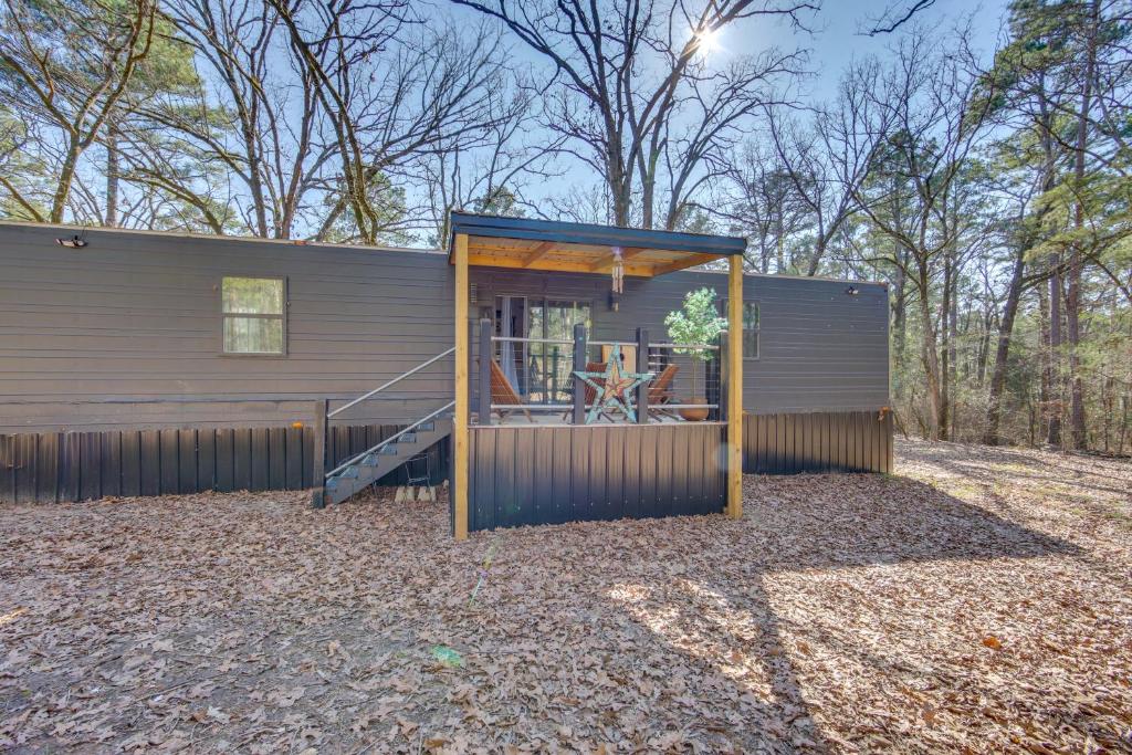 Una pequeña casa con porche y patio. en Winnsboro Tiny House with Trails, Yard Games and More!, en Winnsboro