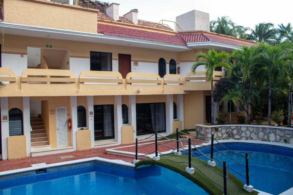 une maison avec une piscine devant dans l'établissement Hotel Vista Caribe Villas, à Playa del Carmen
