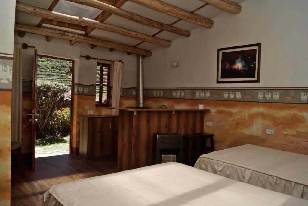 una camera da letto con due letti e un camino di Tradicion Colca a Yanque