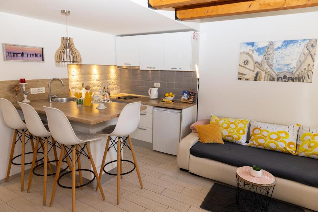a kitchen and living room with a table and a couch at Central Split rooms and apartments Paese in Split