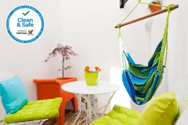 una stanza con un tavolo, due sedie e un'amaca di Lisbon Sant'Ana Apartment Chiado a Lisbona