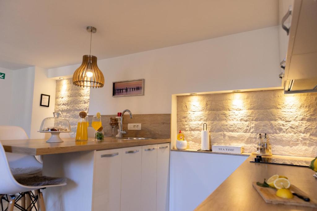 a kitchen with white cabinets and a counter top at Central Split rooms and apartments Paese in Split