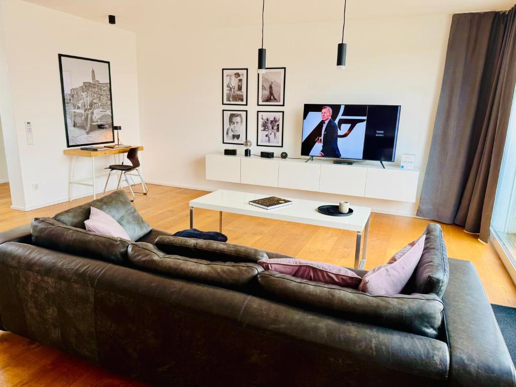 - un salon avec un canapé brun et une télévision dans l'établissement Stilvolles 007 Penthouse nähe Düsseldorf Köln, à Wuppertal