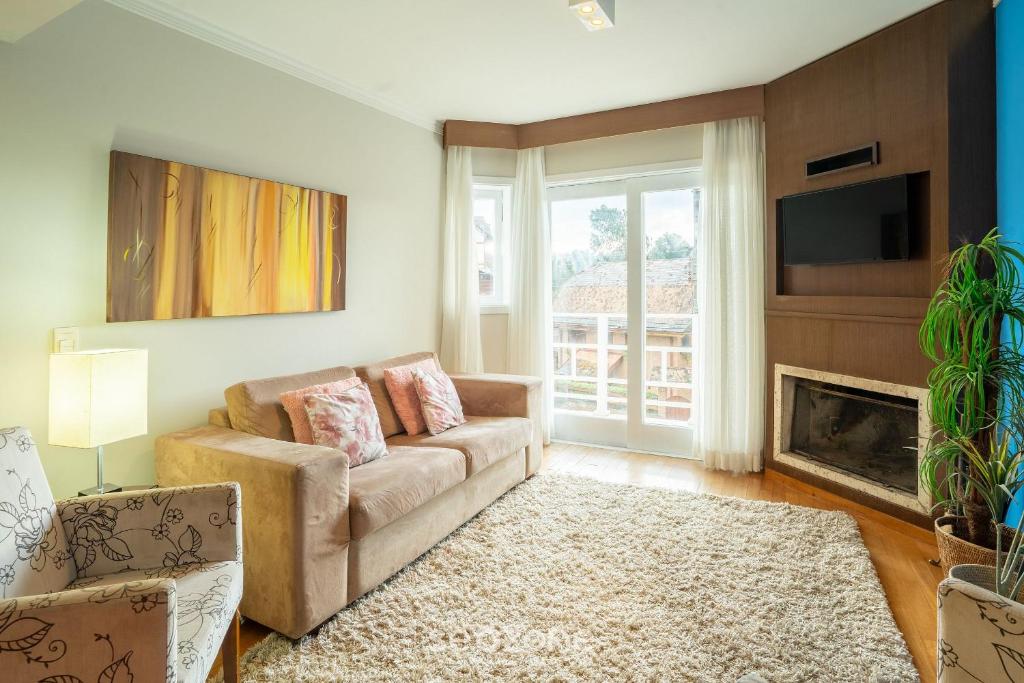 a living room with a couch and a fireplace at Ótimo apto p/ famílias em Campos do Jordão LVR010 in Campos do Jordão