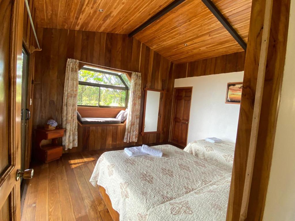 une chambre avec deux lits et une fenêtre dans l'établissement Cabinas Capulin & Farm, à Monteverde Costa Rica