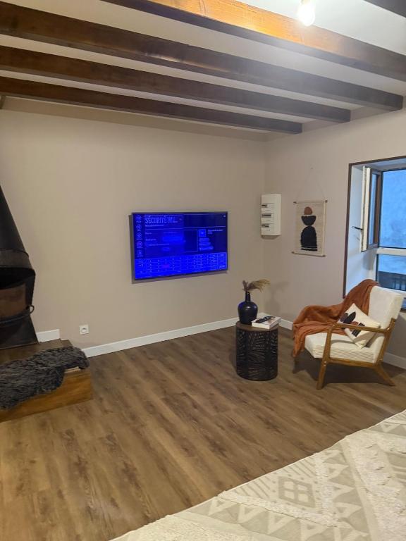 un salon avec une télévision au mur dans l'établissement Un studio a deux pas de lautoroute, à Domarin