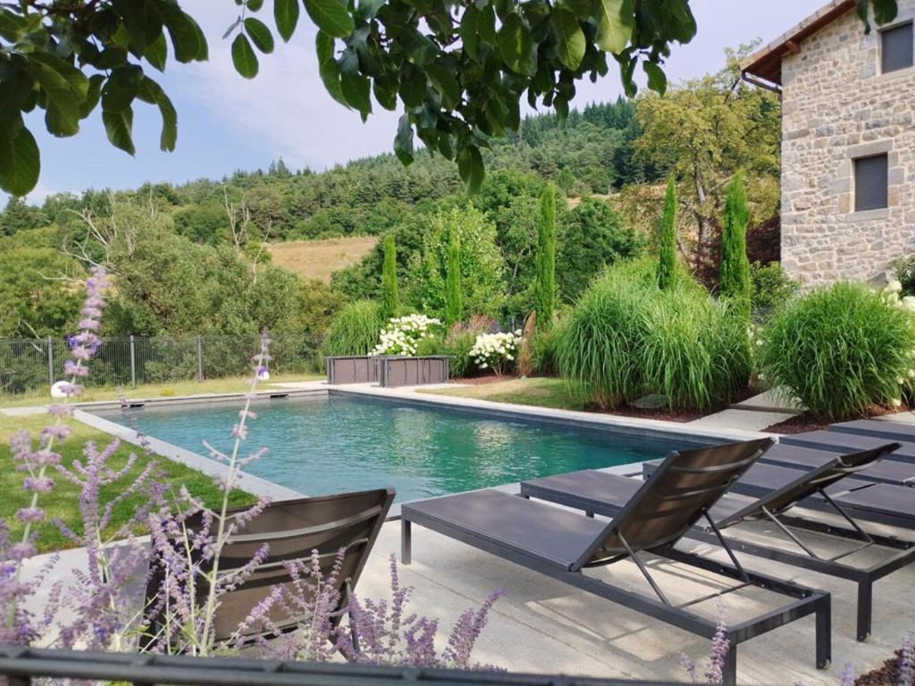 - une piscine dans une cour avec 2 chaises longues dans l'établissement Le Grand Val d'Or - Piscine et Convivialité, à Saint-Prix