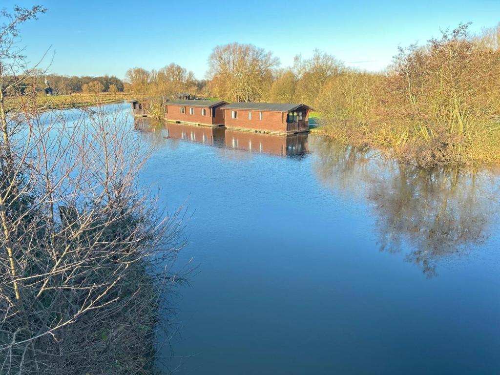 a river with two boats on the water at Ant River Lodge Houseboat in Stalham
