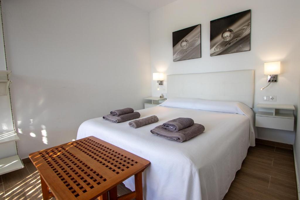 a bedroom with two beds with towels on it at EL ENCANTO Chiclana II in Chiclana de la Frontera