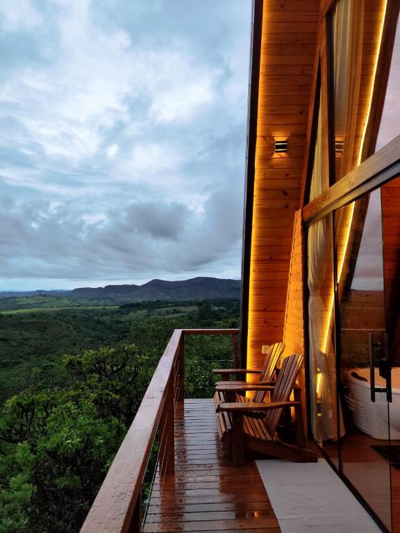 ein Balkon eines Hauses mit zwei Stühlen darauf in der Unterkunft Chalé Refúgio do Sol in Brasilia
