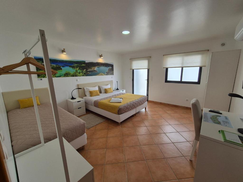 una habitación de hotel con dos camas y una mesa en A Caminho da Ilha, en Ponta Delgada