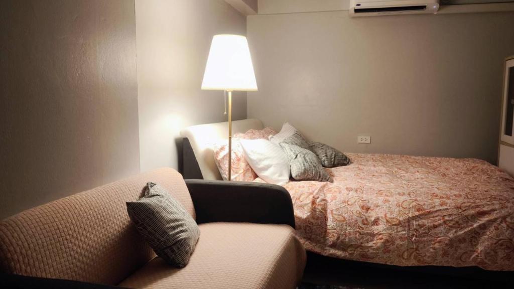 a bedroom with a bed and a lamp and a couch at Patunam Building , Shopping , Airport Rail link in Bangkok