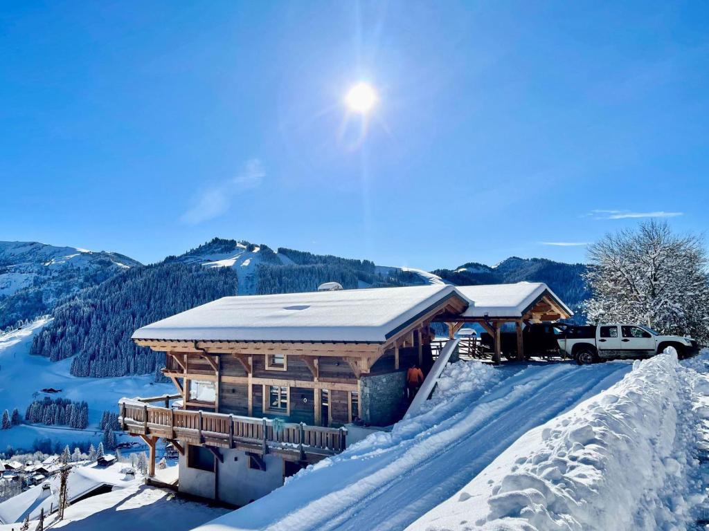 ein Blockhaus im Schnee mit einem LKW vor dem Haus in der Unterkunft Chalet de standing avec jacuzzi et ski-room, 5 chambres - FR-1-505-199 in Notre-Dame-de-Bellecombe