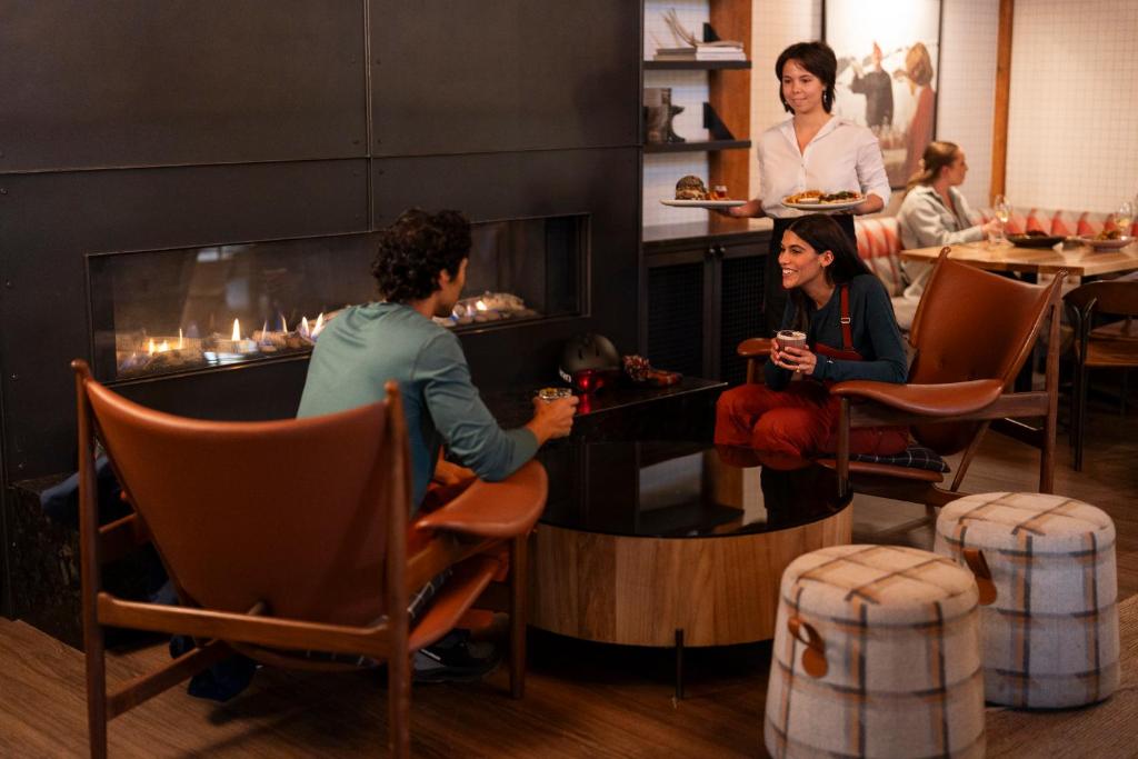 a group of people sitting in a room with a fireplace at Buffalo Mountain Lodge in Banff