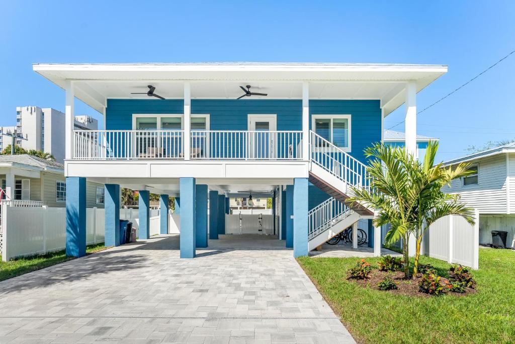 Casa azul con porche blanco y pasarela en 152 Steps to the Beach! Heated Pool - Steps Away - Roelens, en Fort Myers Beach