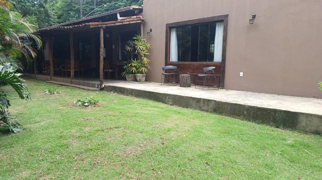 a house with a grass yard next to a building at Loft nas Montanhas! in Nova Lima