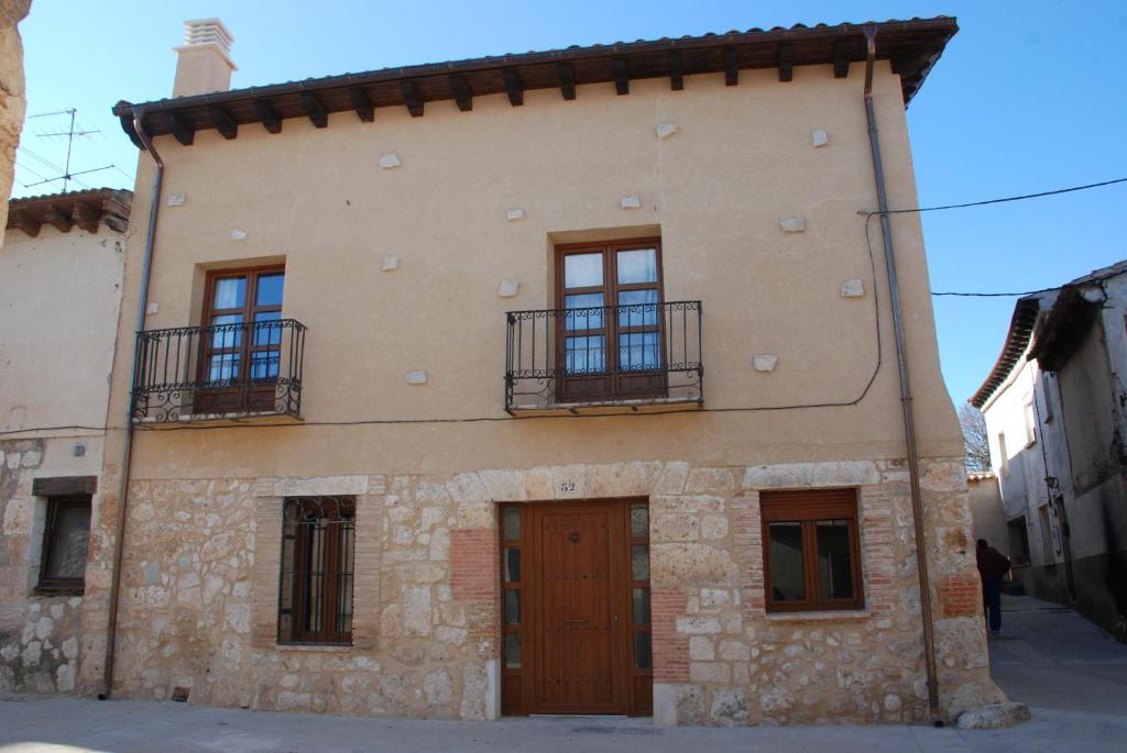 un gran edificio con ventanas y una puerta en Casa Rural Margarita'S en Sotillo de la Ribera
