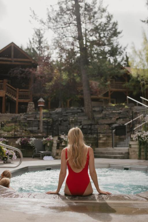 a woman sitting in the water in a swimming pool at Buffalo Mountain Lodge in Banff