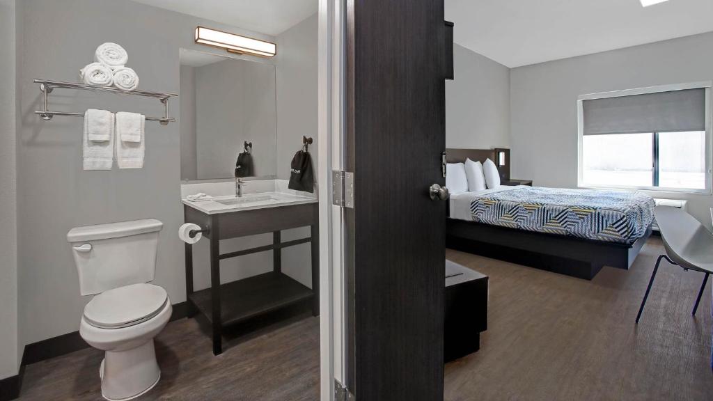 ein Bad mit einem WC, einem Waschbecken und einem Bett in der Unterkunft Fort Worth TX Downtown East in Fort Worth