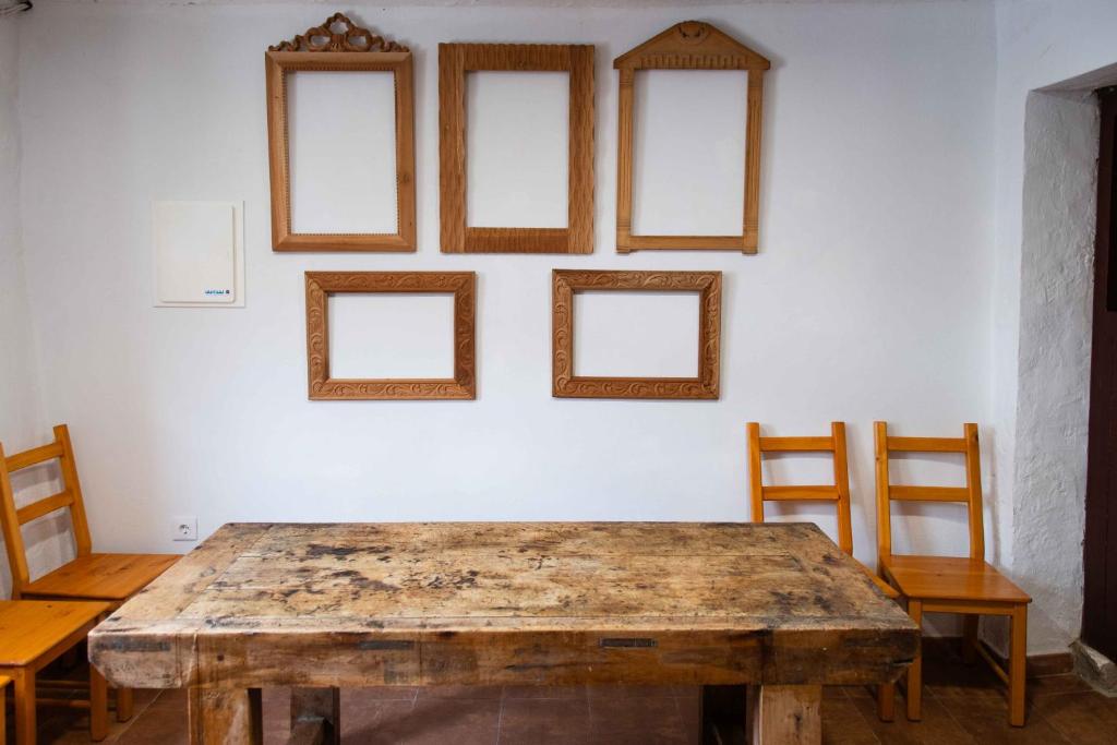 Cette chambre dispose d'une table en bois et de 4 photos sur le mur. dans l'établissement Elrubiorural Casa el rubio Corcolilla, à Corcolilla