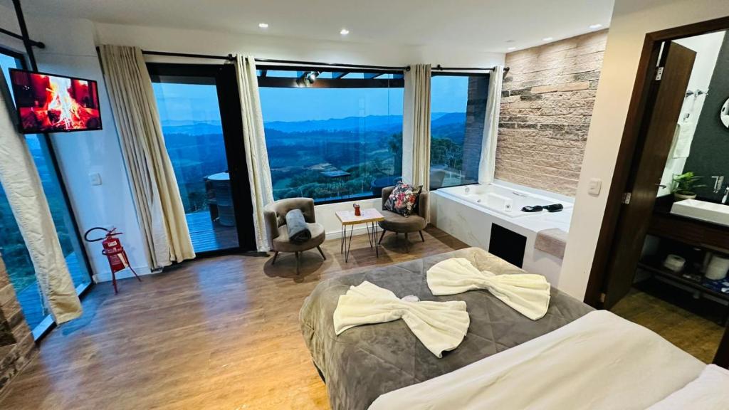 Un dormitorio con una cama grande y una ventana grande. en Ninho da Águia - Cabana A, en Urubici