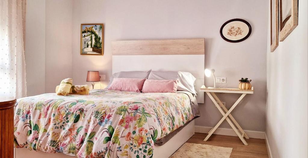 Un dormitorio con una cama con una colcha floral. en Moderno y acogedor Parquesol Antequera, en Antequera