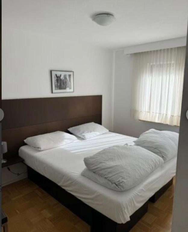 ein Bett mit weißer Bettwäsche und Kissen in einem Schlafzimmer in der Unterkunft Zum Griechen Restaurant und Pension in Forchtenberg