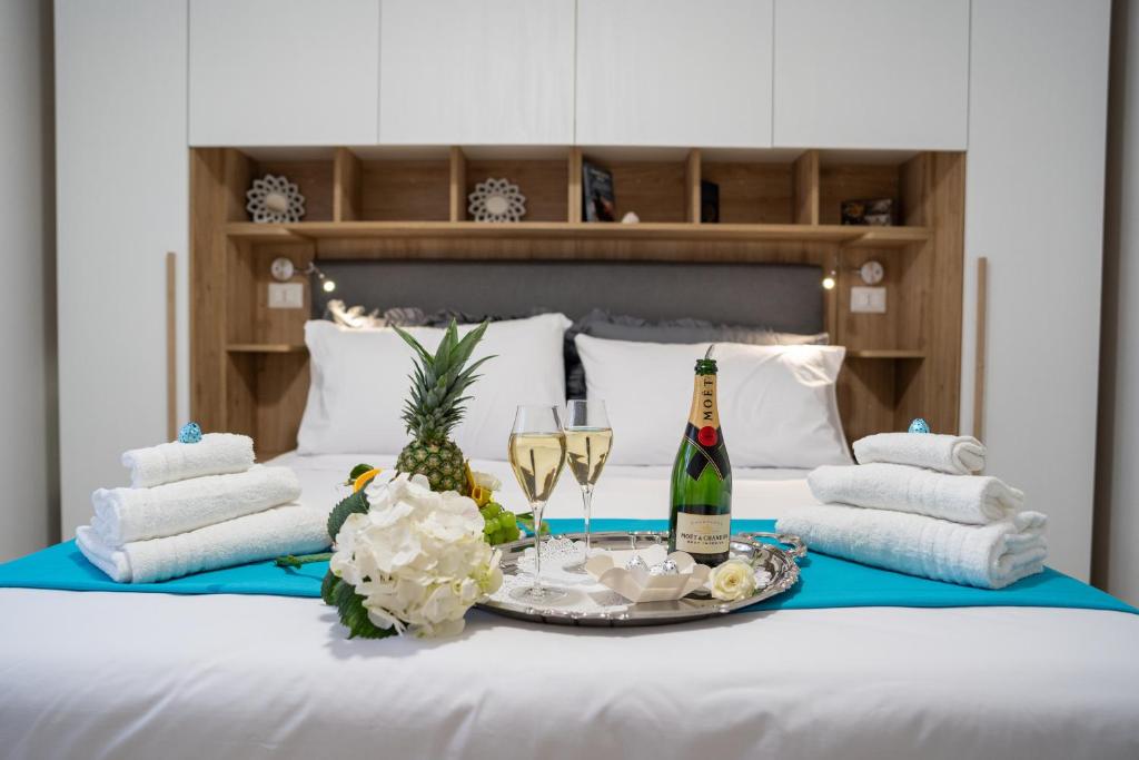 a table with champagne glasses and flowers on a bed at B&B Nonna Marisa in Castellammare di Stabia
