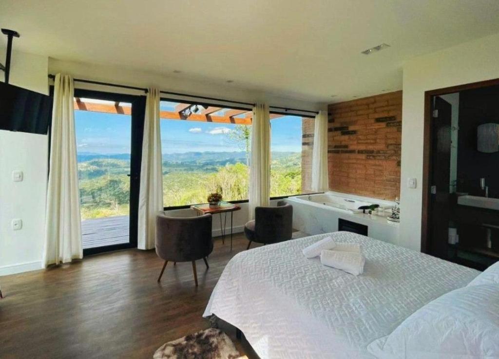 una camera con letto e una grande finestra con vista di Ninho da Águia - Cabana B a Urubici