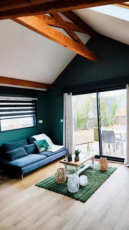 un salon avec un canapé bleu et une table dans l'établissement Loulo 'dge, à Saint-Donan