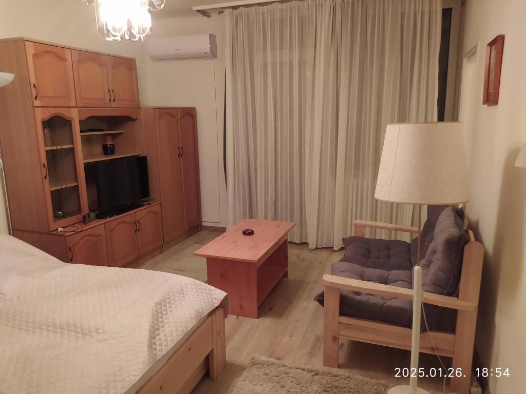 a bedroom with a bed and a chair and a table at 4 turtles apartman in Budapest