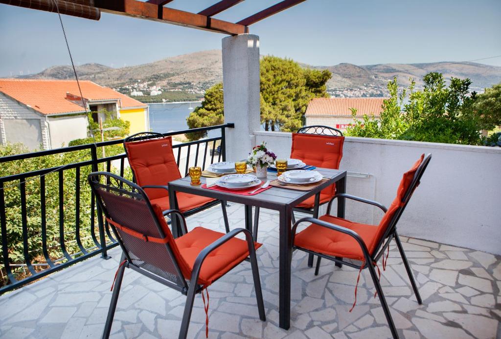 a table and chairs on a balcony with a view of the ocean at Apartments AstaLaVIsta in Okrug Donji