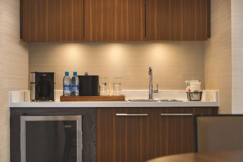 a kitchen counter with a sink and a microwave at Coast Edmonton Plaza Hotel by APA in Edmonton