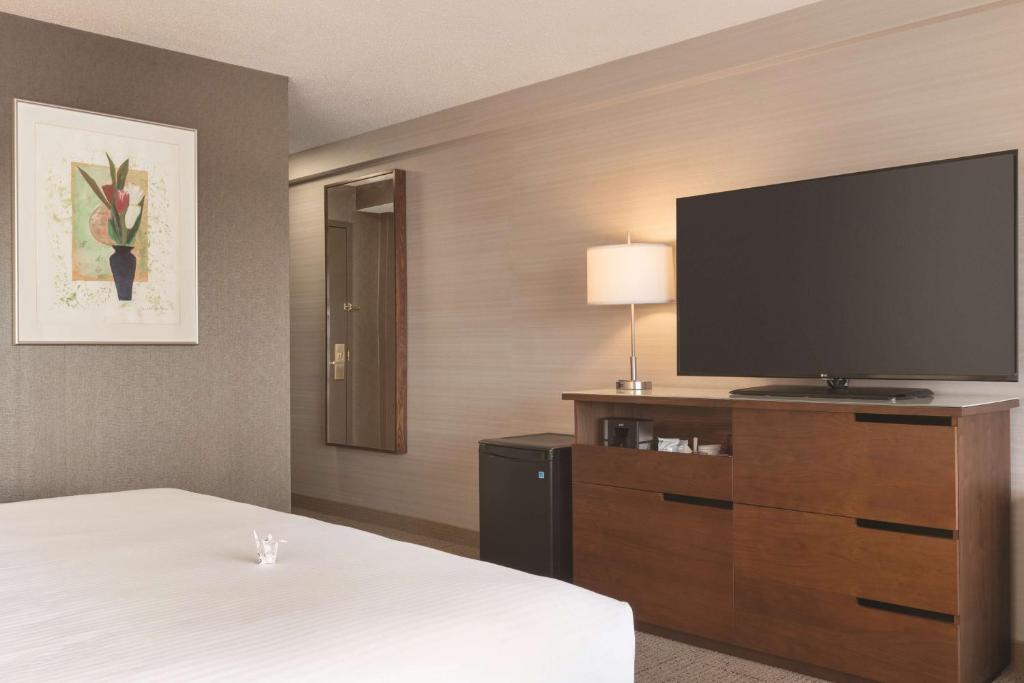 a hotel room with a bed and a flat screen tv at Coast Edmonton Plaza Hotel by APA in Edmonton