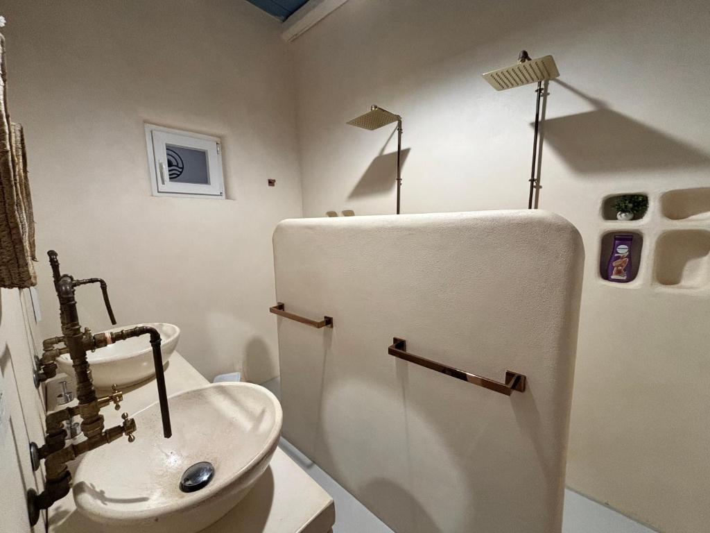 a bathroom with a sink and a white refrigerator at Casa Mediterranea Jacuzzi riscaldata con Caminetto in Specchiolla