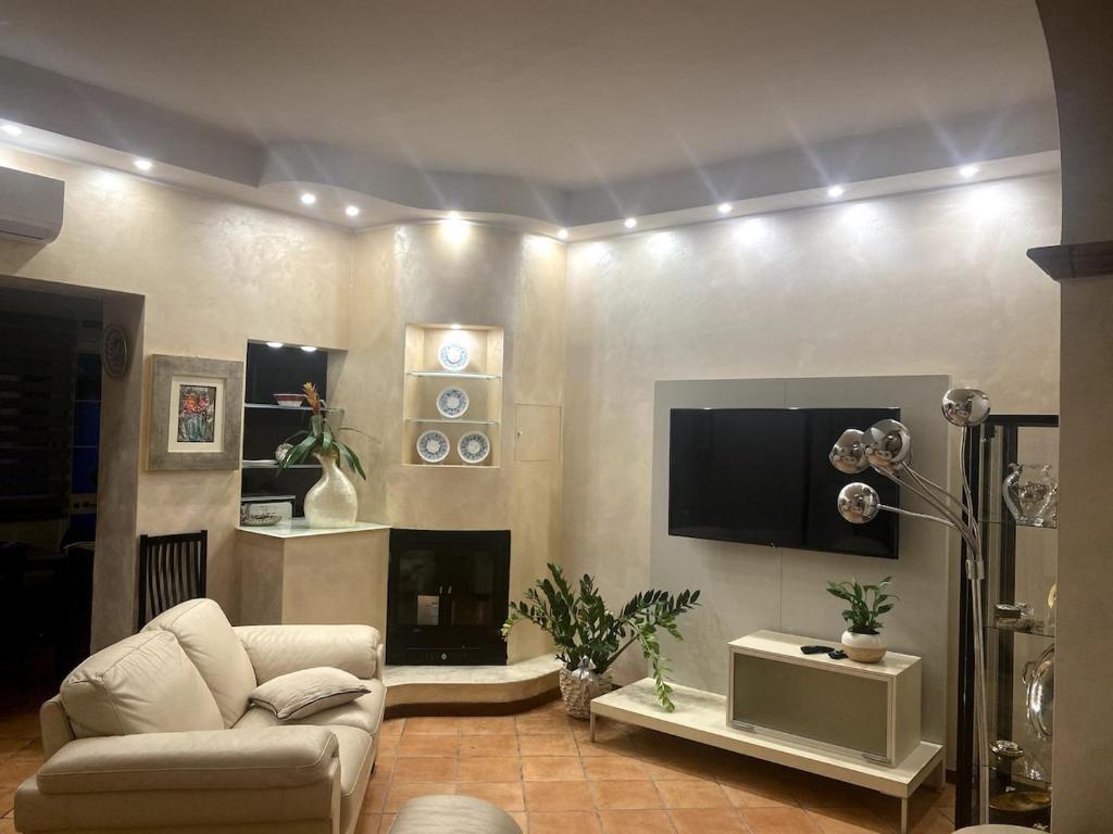 a living room with a couch and a tv at Art & Family Ideal for families in Viareggio