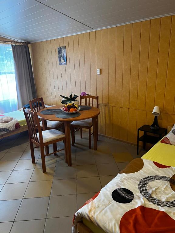 una camera con tavolo e sedie e una camera con letti di Domki Letniskowe Pod Skamieniałym Miastem a Ciężkowice
