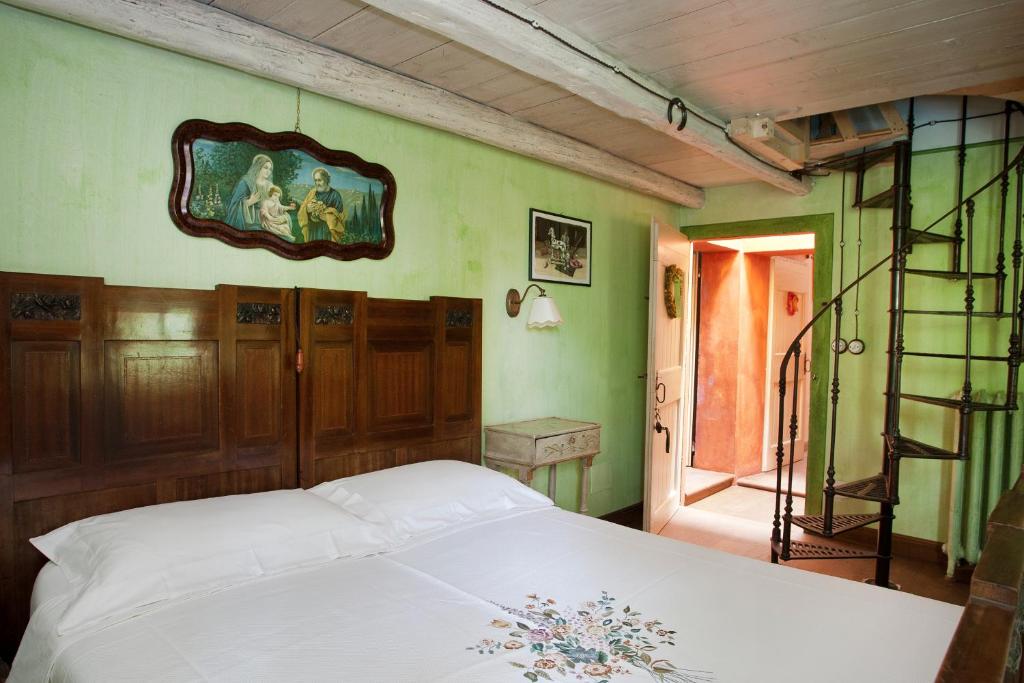 a bedroom with a white bed and green walls at Casa Delle Meridiane in Ravenna