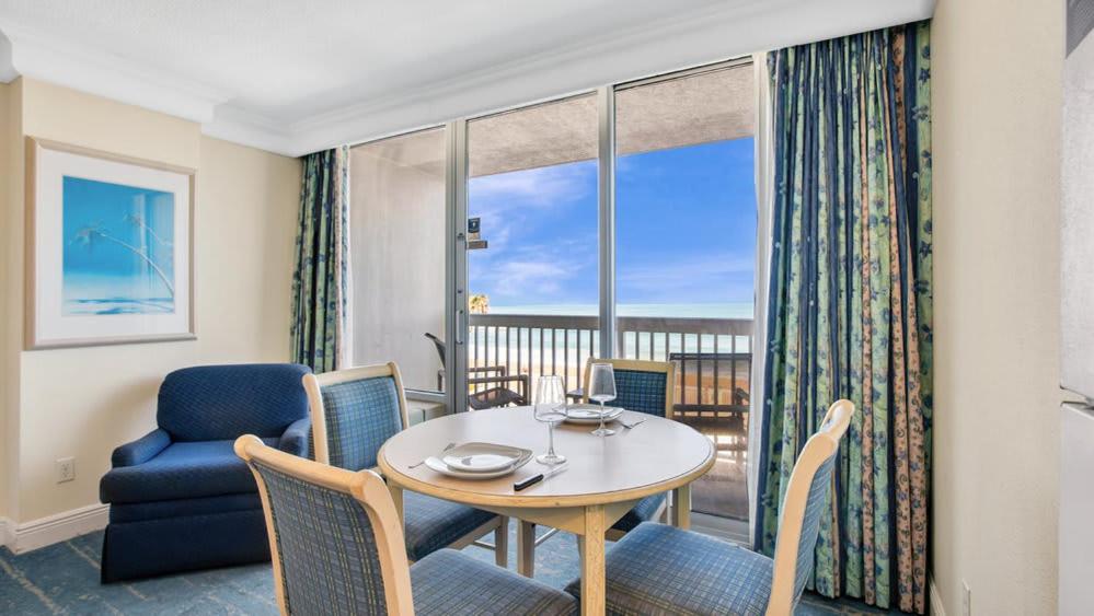 a living room with a table and chairs and a window at Oceanfront Studio in Daytona Beach Resort in Daytona Beach