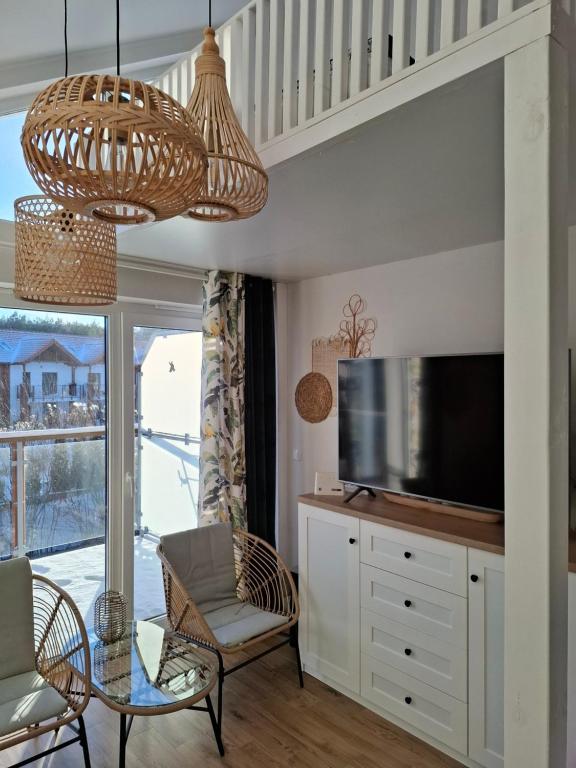 a living room with a television and a table and chairs at Apartament Piaskowa 2 in Żarnowska
