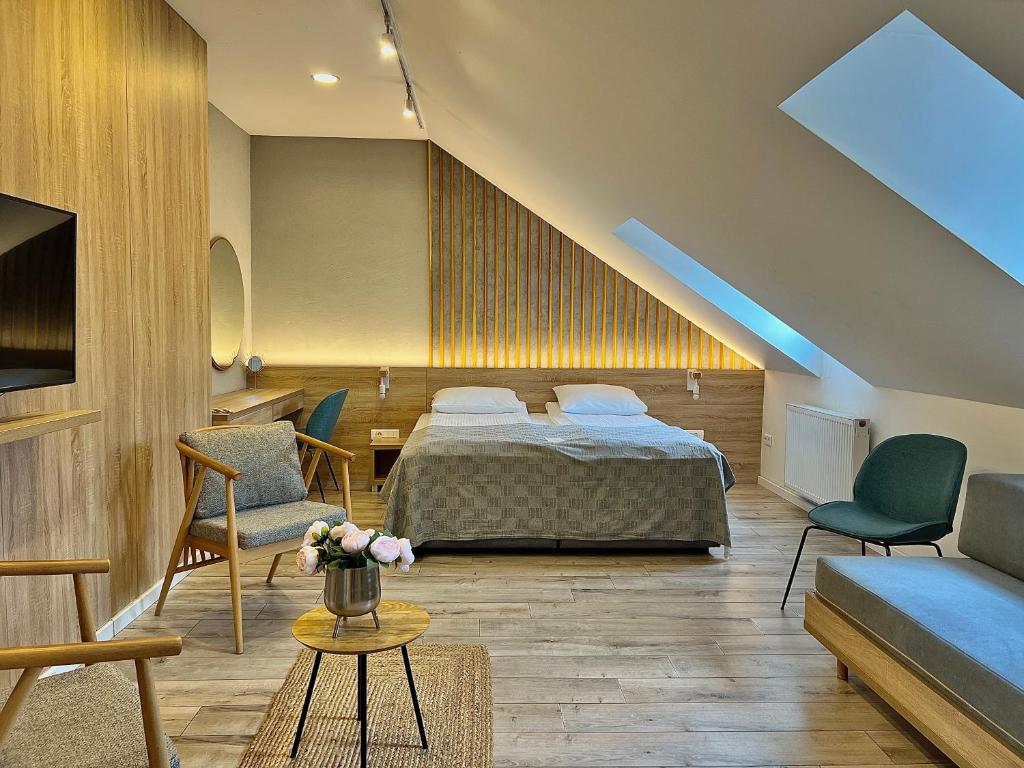 a bedroom with a bed and chairs and a couch at City Boutique Hotel in Sarajevo