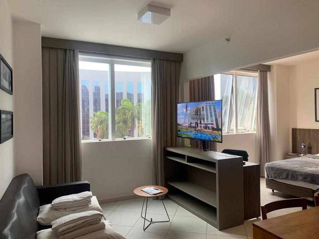 a living room with a bed and a television in it at Hotel Condominio Barretos Park Hotel in Barretos