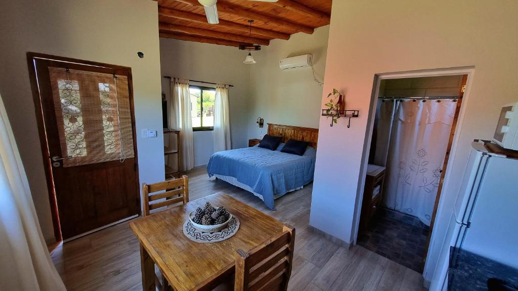 ein Schlafzimmer mit einem Bett und einem Tisch in einem Zimmer in der Unterkunft Estancia Helvetia in San José