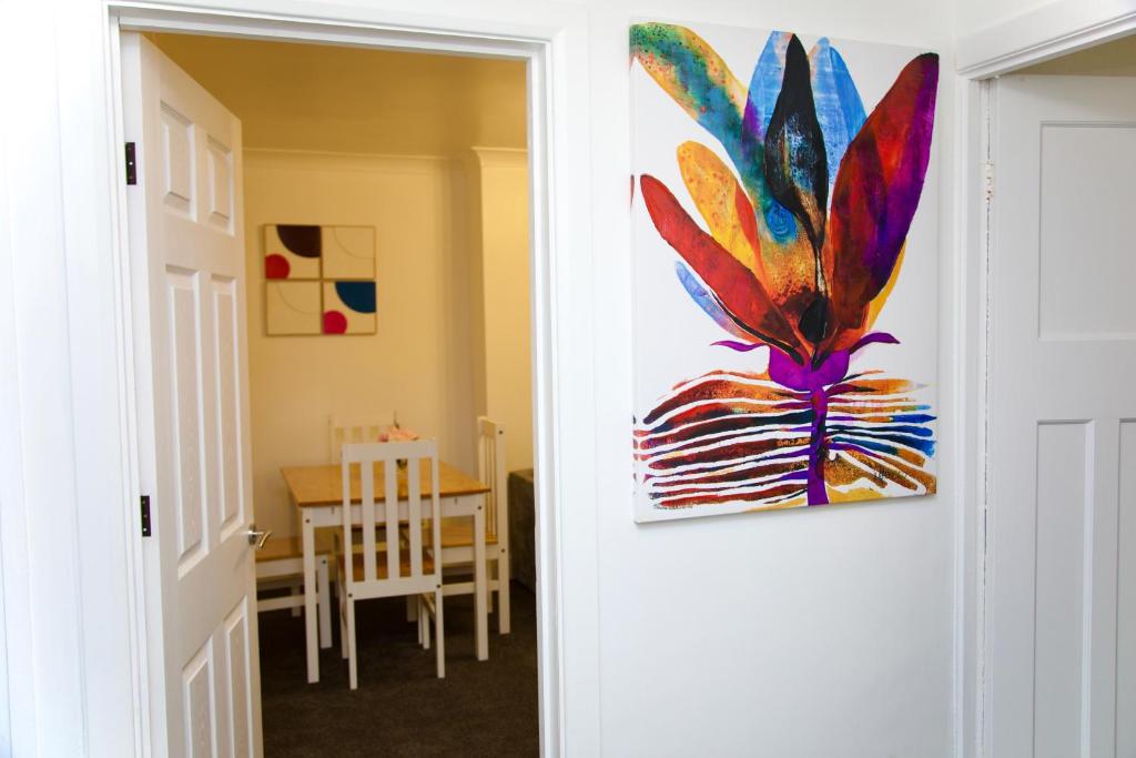 a door leading into a dining room with a painting on the wall at Cosy & Stylish 2 Bed Ground Floor Flat in Dartford in Dartford