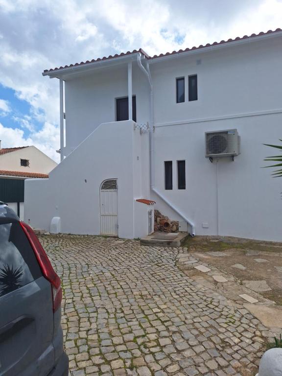 a white house with a car parked in front of it at Monteverde in Monte Negro