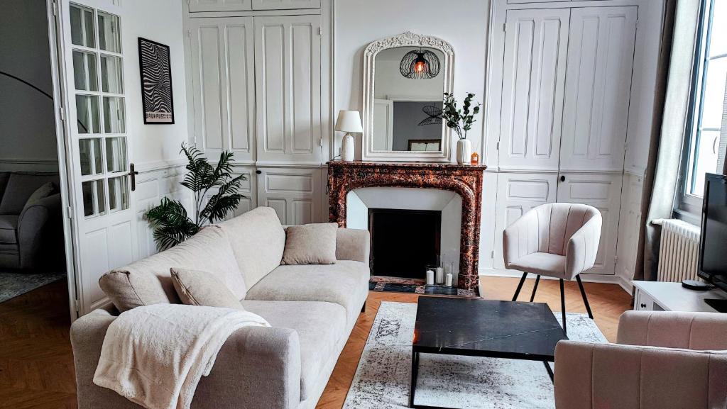 un salon avec un canapé et une cheminée dans l'établissement Grande maison bourgeoise La Flèche, centre ville, à La Flèche